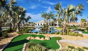 A golf course with multiple pools and palm trees.