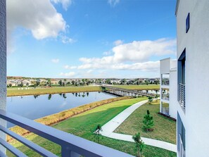 A residential area with a pond, a bridge, and modern houses.