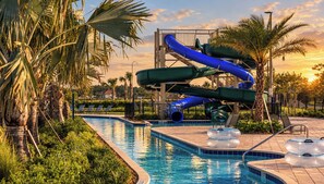 A swimming pool with a water slide and inflatable rings.
