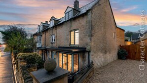 A stone house with a sloped roof, a covered porch, and a gravel driveway. - Eastnor (Moreton-in-Marsh)