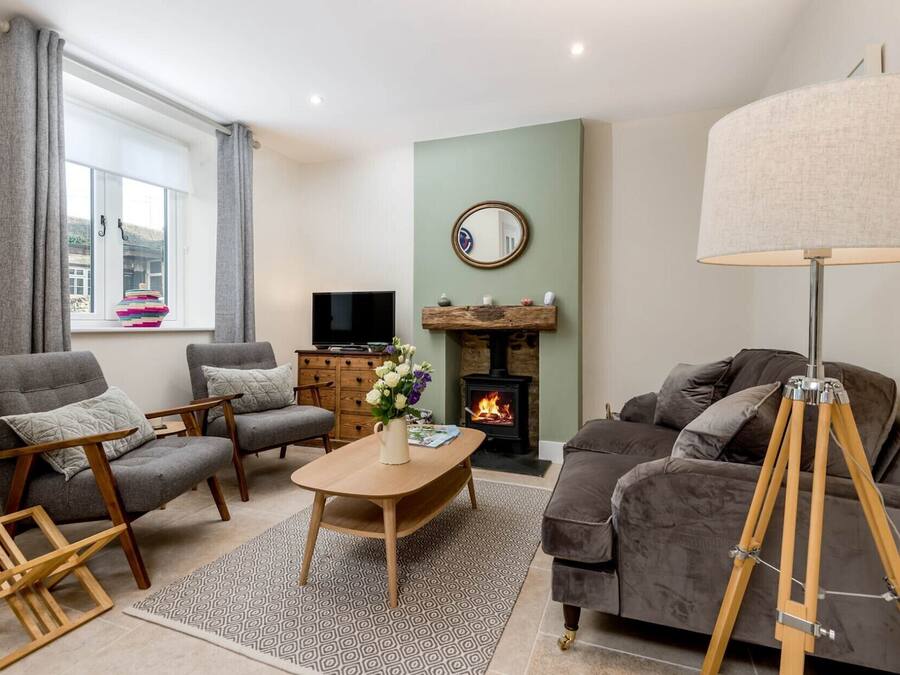 A living room with a fireplace, a television, and a lamp.