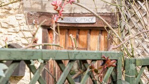 A rustic wooden door with a sign above it that reads "COTTAGE". - Carter's Cottage (Cheltenham)