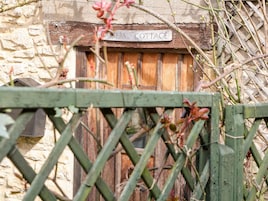 Una puerta de madera rústica con un letrero que dice "COTTAGE".
