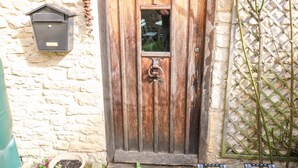 A rustic wooden door with a sign above it reading "CARTERS COTTAGE." - Carter's Cottage (Cheltenham)