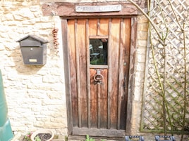 Una rústica puerta de madera con un letrero que dice "CARTERS COTTAGE".