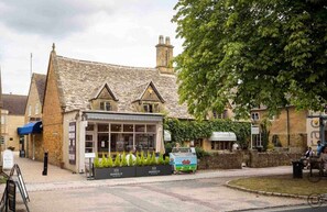 A traditional stone building with a shop front and a parked ice cream van.
