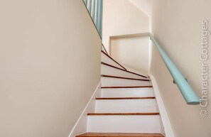 A staircase with white walls and wooden steps.