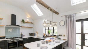 Una cocina moderna con una isla central, horno integrado y un ventanal amplio.