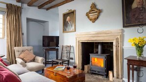 Een gezellige woonkamer met een open haard, een televisie en comfortabele zitplaatsen.