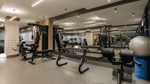 A modern gym with various exercise equipment, including dumbbells, benches, and weight machines. - Somerset City Centre Atyrau (Atyrau)