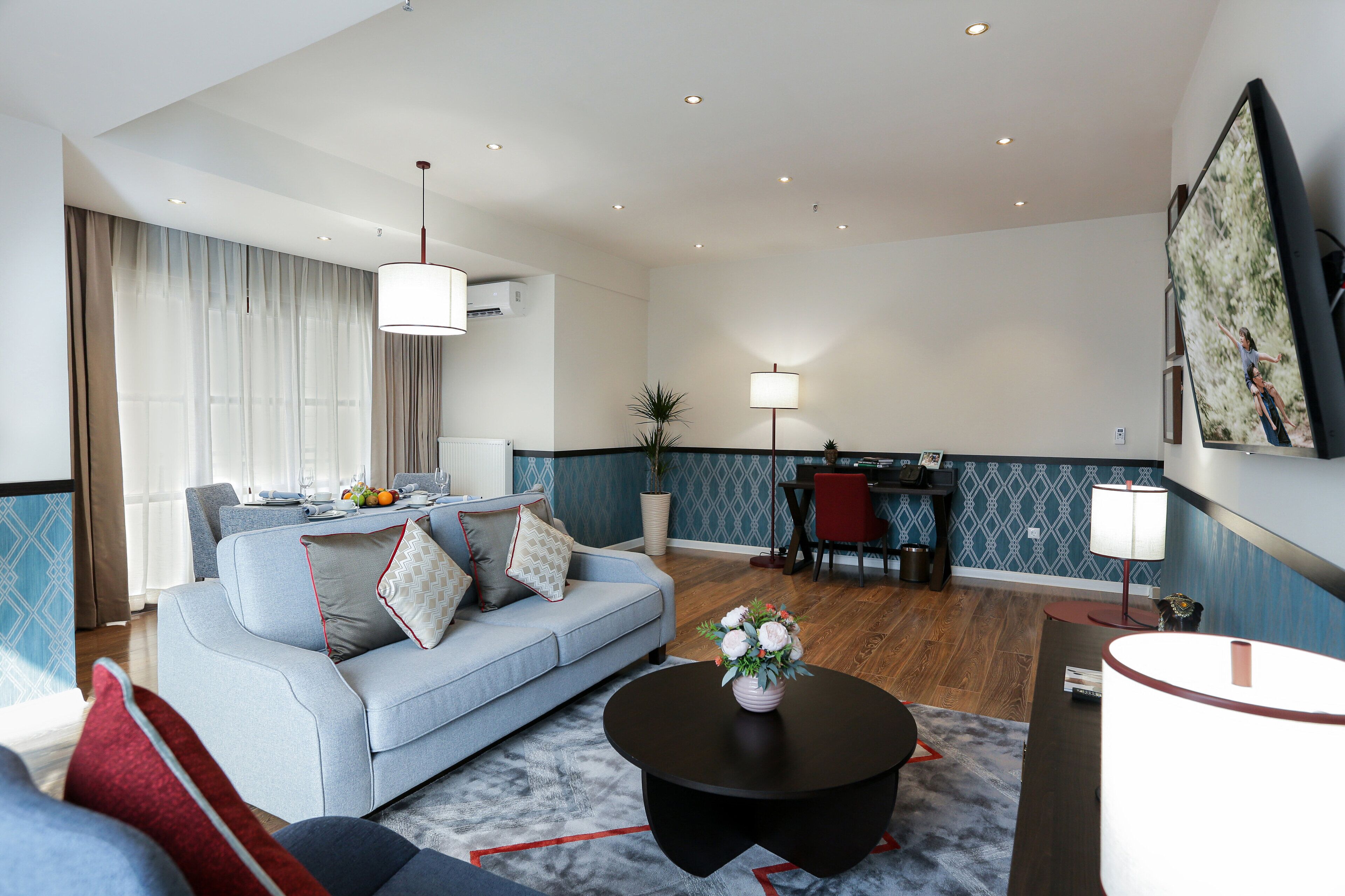 Een moderne woonkamer met een bank, salontafel en een eethoek.