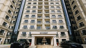 A high-rise building with a central entrance labeled "SOMERSET." - Somerset City Centre Atyrau (Atyrau)