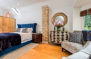 A bedroom with a bed, a dresser, a mirror, and a window.