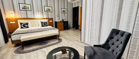A bedroom with a bed, bedside tables, a chair, and a round coffee table.