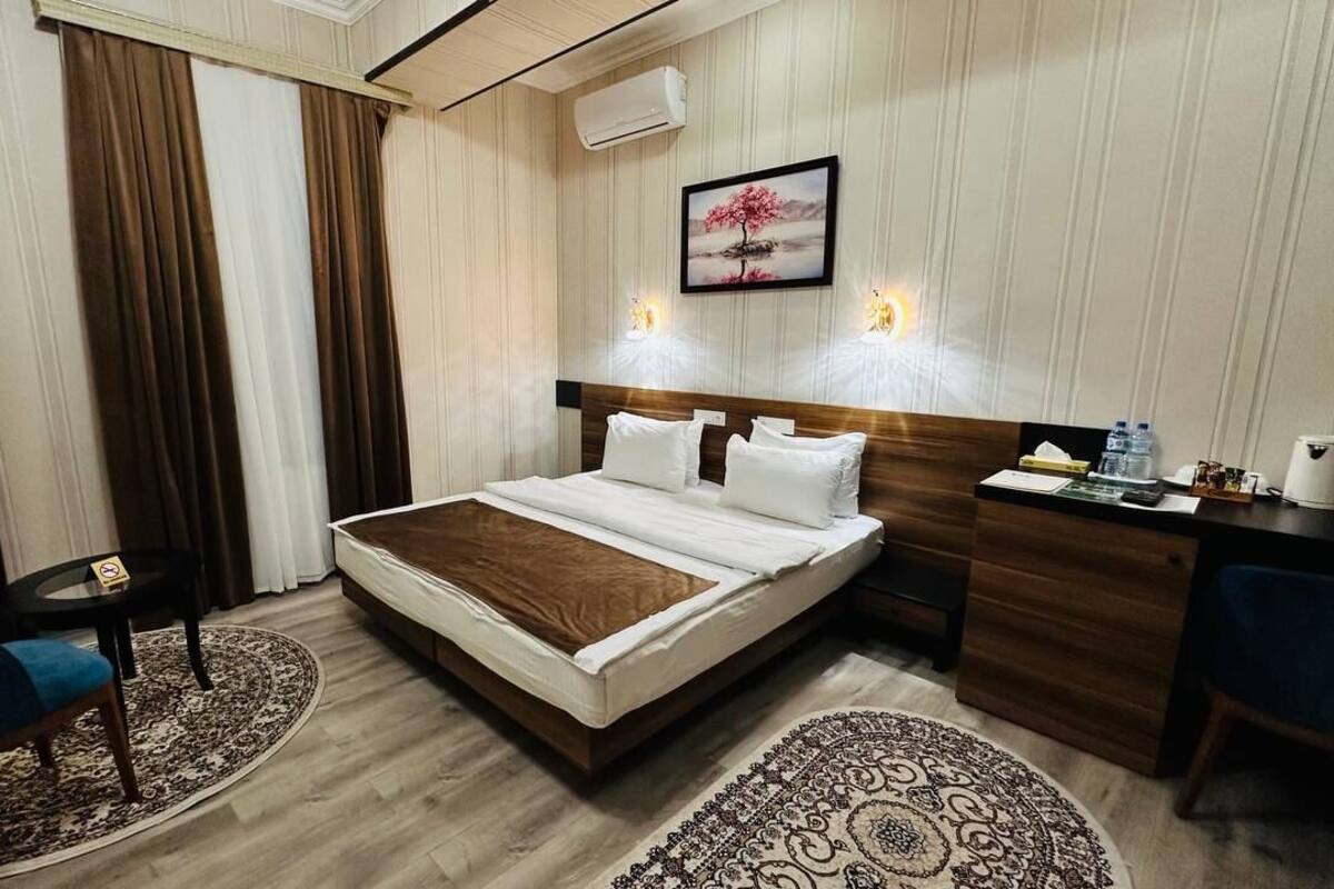Ein Hotelzimmer mit einem Bett, einem Schreibtisch, einem Sessel und einem kleinen Tisch.