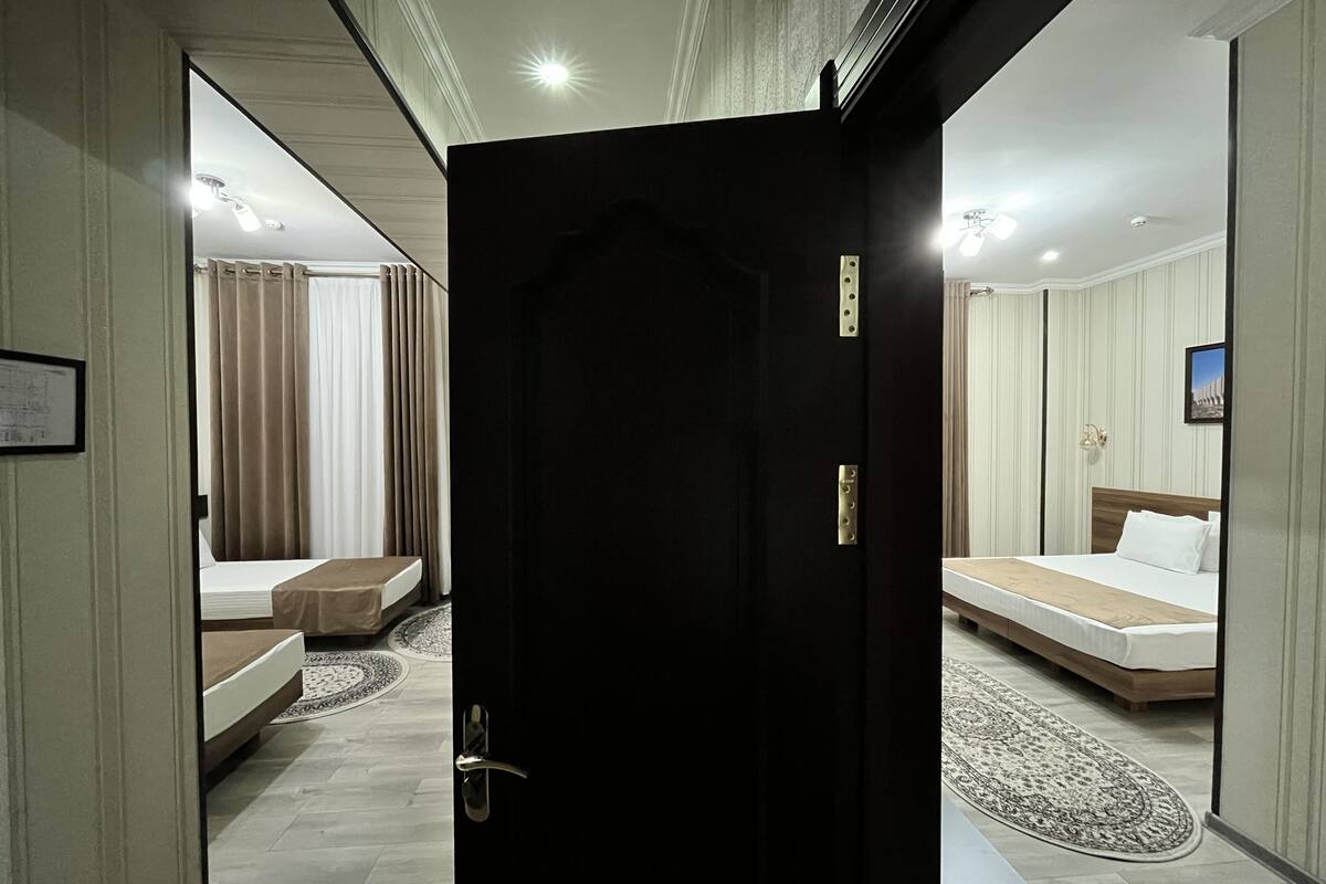 Ein Hotelzimmer mit Bett, einer Couch, einem kleinen Tisch und einem Spiegel.