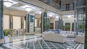 A spacious lobby with a marble floor, elegant furniture, and decorative chandeliers. - Garden Plaza Bukhara (Bukhara)