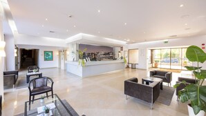 A spacious lobby with a reception desk, seating area, and large windows. - Clube do Lago Hotel (Cascais)