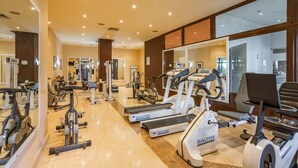 A gym with various exercise equipment, including treadmills and weight machines, and mirrors on the walls. - Clube do Lago Hotel (Cascais)