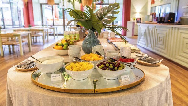 A buffet table with various food items and a decorative plant centerpiece. - Clube do Lago Hotel (Cascais)