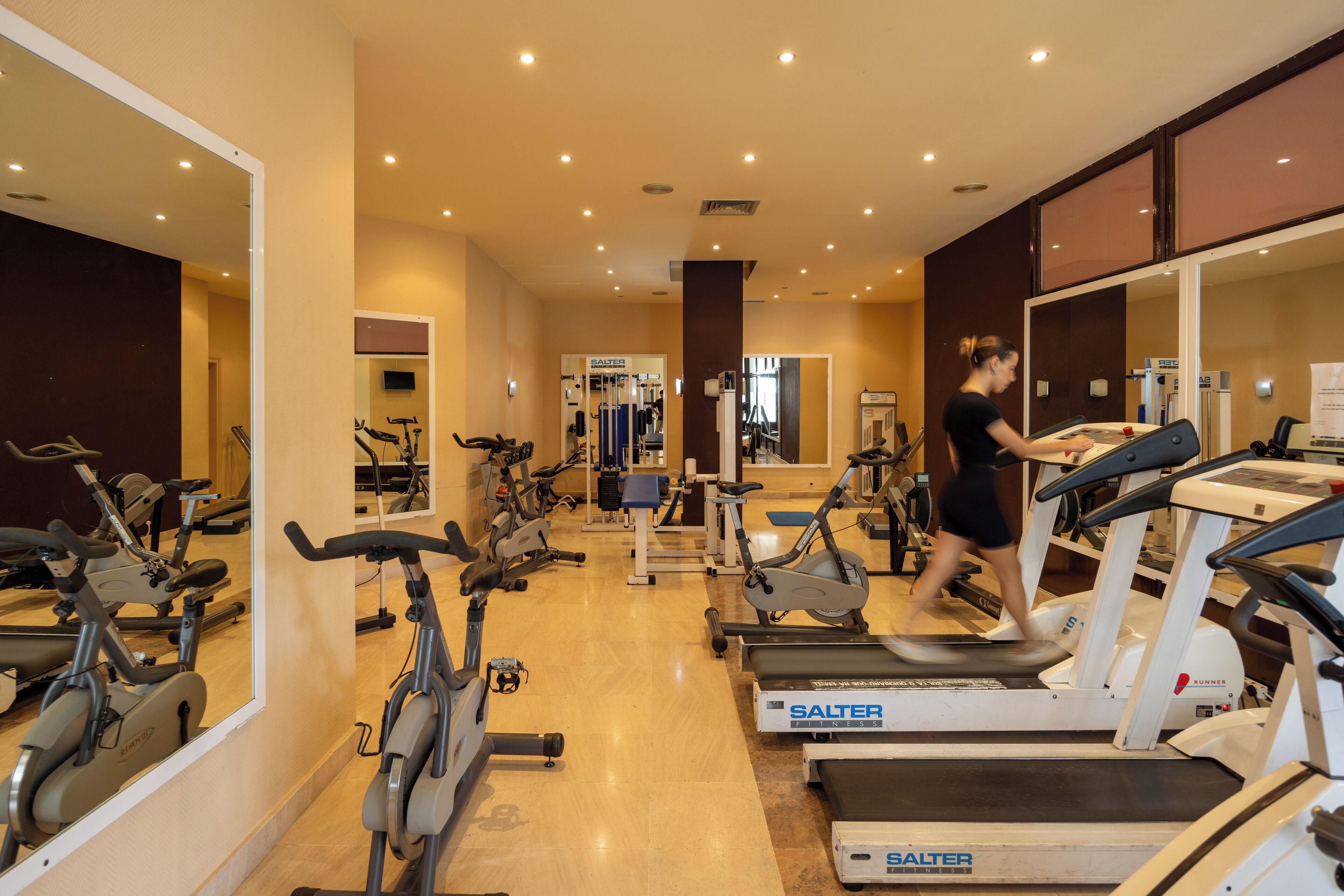 A gym with treadmills, stationary bikes, and weight machines.
