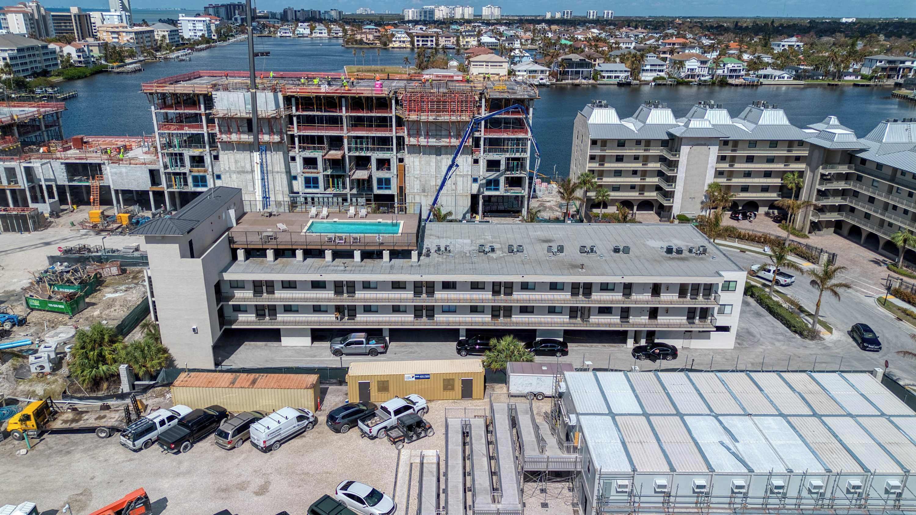 Un hôtel à plusieurs étages doté d’une piscine, d’un parking et offrant une vue sur le port de plaisance.