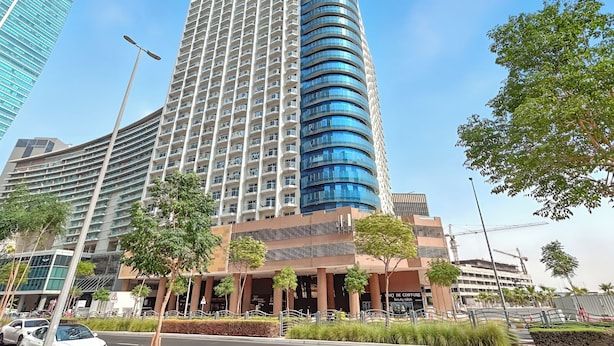 Un hotel moderno de gran altura con fachada curva, múltiples balcones y diseño contemporáneo.