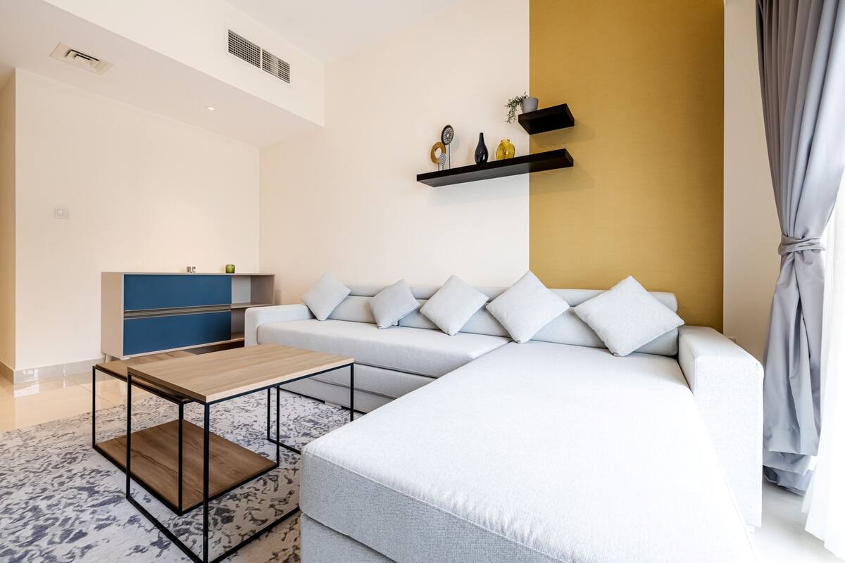 Een moderne woonkamer met een bank, een salontafel en een blauwe kast.
