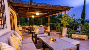 An outdoor patio with a covered seating area, a dining table, and a candle centerpiece. - 3 Bedroom Family Villa in Javea (Javea / Xàbia)