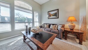 A living room with a large window, a sofa, a coffee table, and a lamp. - FANTASTIC Scottsdale location! Close to Waste Management Open, and Westworld!! (Scottsdale)