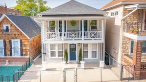 A two-story house with a balcony, a front porch, and a garage. - 3 KING Beds + Walk to River Market + Coffee (Kansas City)