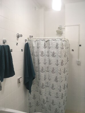 Regadera, secadora de cabello, toallas, papel de baño 