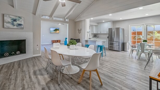 A spacious kitchen with white cabinets, a stainless steel refrigerator, and a built-in oven. - Funtierland + Adventure House + Close to Disney + Renovated+ Pool (Anaheim)