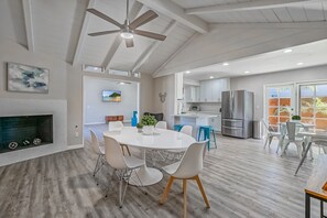 A spacious kitchen with white cabinets, a stainless steel refrigerator, and a built-in oven. - Funtierland + Adventure House + Close to Disney + Renovated+ Pool (Anaheim)