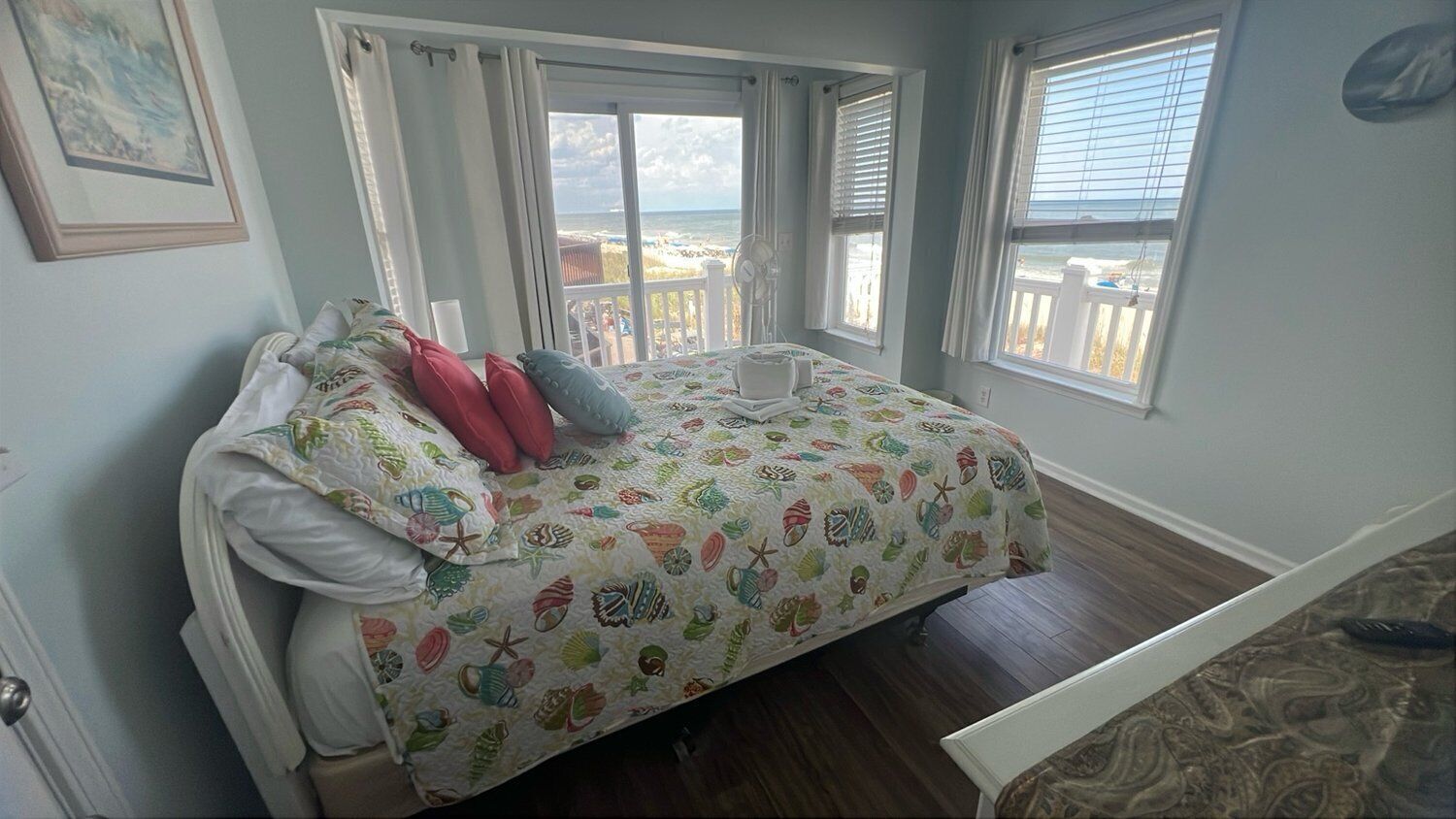Une chambre à coucher avec un lit, une fenêtre donnant sur la plage et une porte.