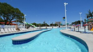 Une piscine avec plusieurs couloirs de nage, des chaises longues et un poste de surveillance pour les sauveteurs.