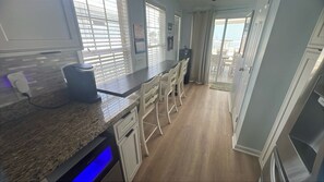 A kitchen with a granite countertop, white cabinetry, and a built-in dishwasher.