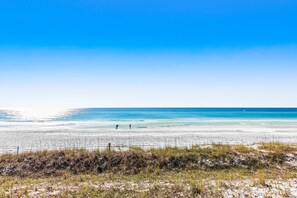 Enjoy a serene beach experience with a wide sandy shore and calm sea.