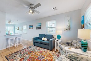 Relax in this inviting living area with a comfortable sofa set, armchair, and vibrant rug.