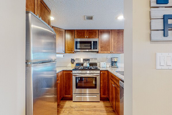 Fully equipped kitchen with refrigerator, microwave, oven, and dishwasher.