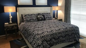 Een slaapkamer met een groot bed, twee bedlampen en een plafondventilator.