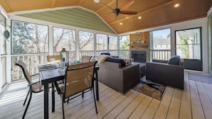 A covered outdoor area with a dining table, chairs, and wicker furniture. - Much to love Guest favorite Evergreen Hideaway waterfront home w/ dock. Pets ok (Gainesville)