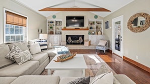 A living room with a fireplace, sofa, coffee table, and decorative items. - Much to love Guest favorite Evergreen Hideaway waterfront home w/ dock. Pets ok (Gainesville)