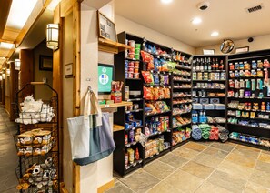 A store interior with shelves stocked with snacks, beverages, and household items.