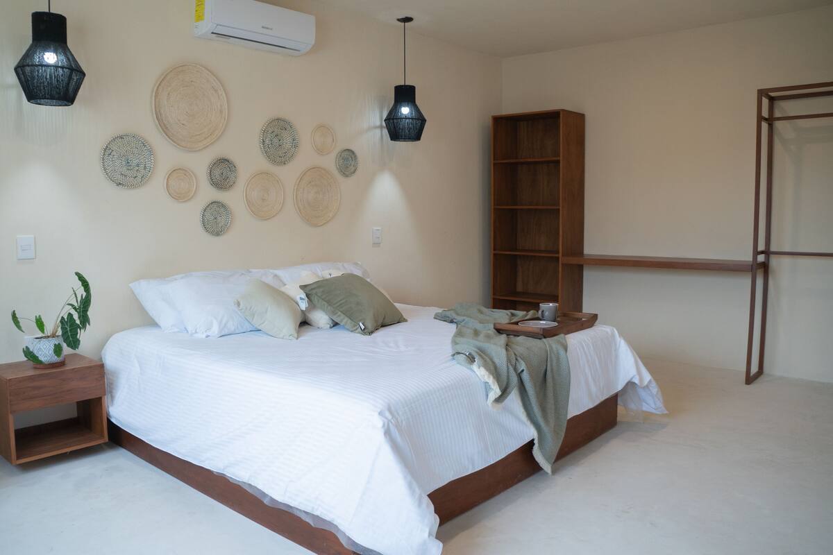 Une chambre à coucher comprenant un lit, des tables de chevet, une bibliothèque en bois et des éléments de décoration murale.