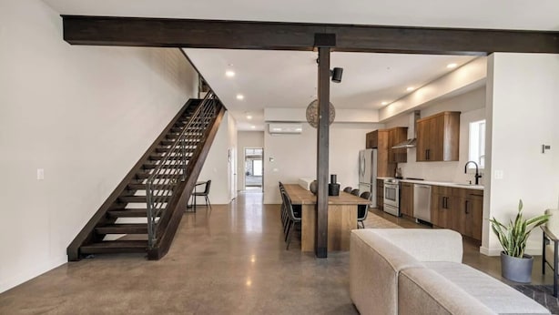 Un intérieur moderne comprenant un escalier, un coin repas et une cuisine.