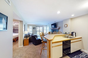 Cozy room with a kitchenette, dining table, and seating area.