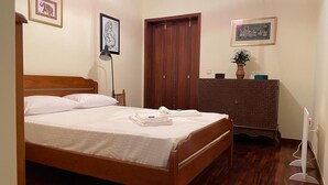 A bedroom with a wooden bed, a dresser, and a door.