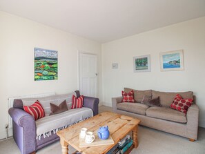 A living room with two sofas, a coffee table, and wall art.