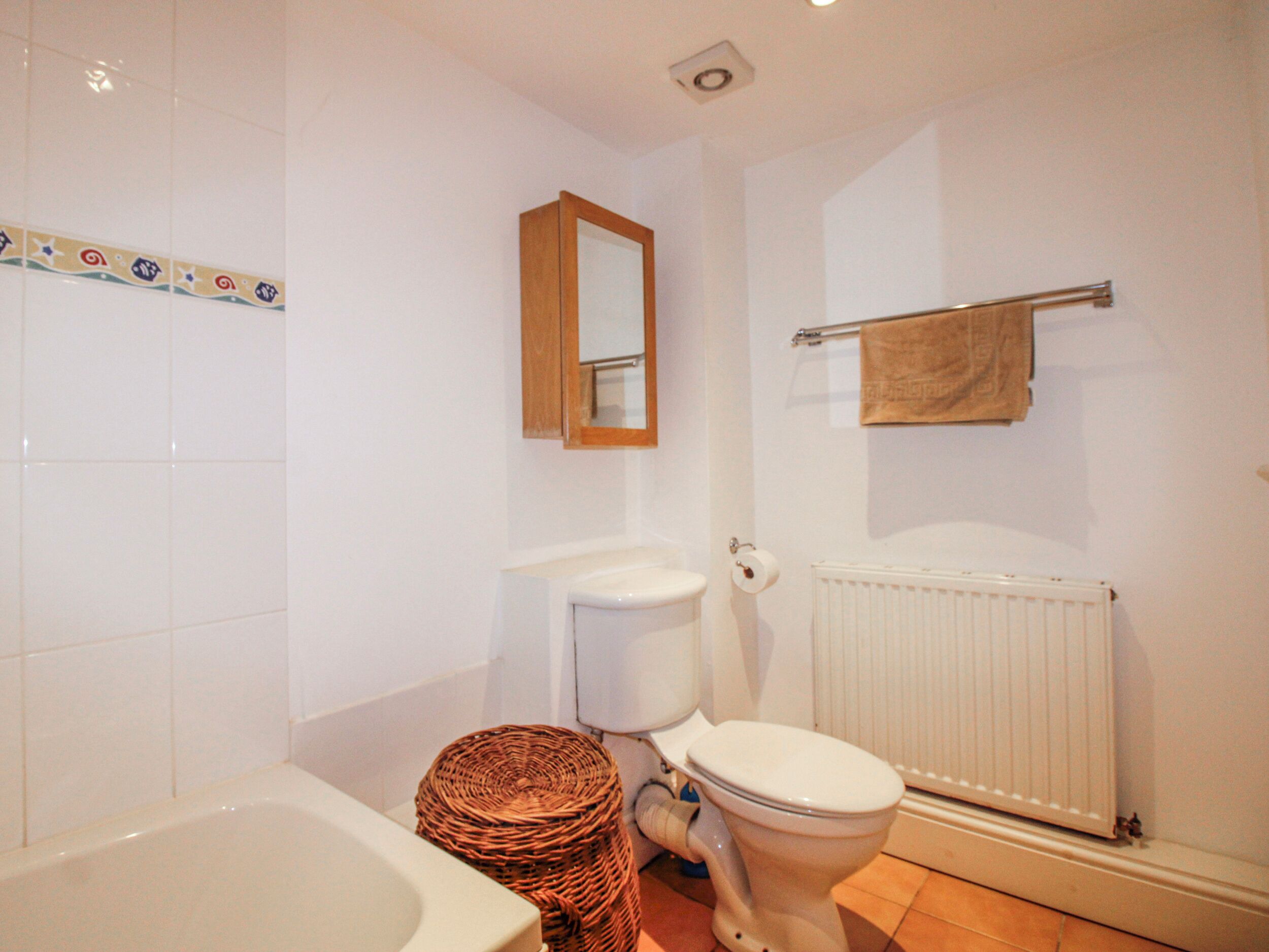 Un bagno con vasca, WC e termosifone.